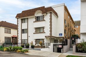 Los Angeles apartment for rent - A white and brown building with a black gate in front.