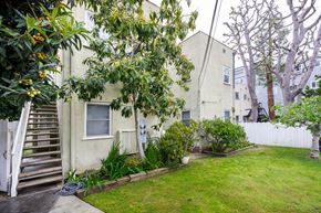 Beverly Hills apartment for rent - the backyard of an apartment building with a lawn and tree