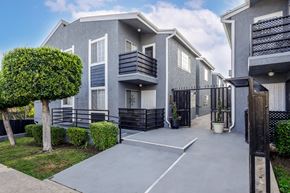 Los Angeles apartment for rent - a grey building with a driveway and a tree in front of it