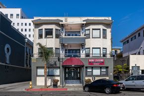 Long Beach apartment for rent - a building with a red awning and a car parked in front of it