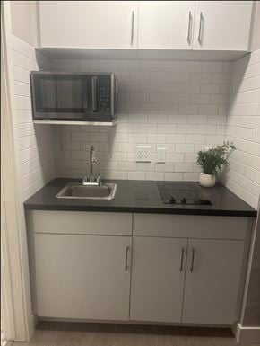 Los Angeles apartment for rent - A kitchen with a black countertop and white cabinets.