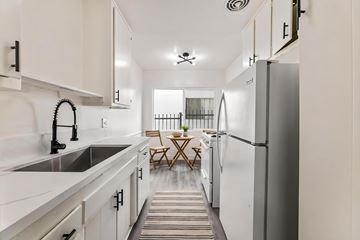 Los Angeles apartment for rent - A kitchen with white cabinets and a striped rug on the floor.
