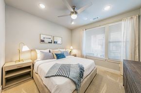 Austin townhouse for rent - A bedroom with a bed, nightstand, and window.
