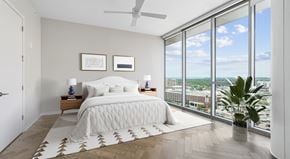 Nashville apartment for rent - A bedroom with a large bed and a view of the city.