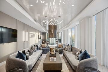 Philadelphia apartment for rent - A modern living room with grey couches and a chandelier.