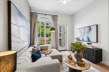 Las Vegas apartment for rent - A modern living room with a grey sofa, a wooden coffee table, and a large painting on the wall.