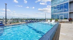 Nashville apartment for rent - A large swimming pool with a blue tiled edge and a white chair on the right side.