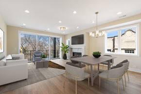 Chicago apartment for rent - A modern living room with a fireplace and a dining table set up.