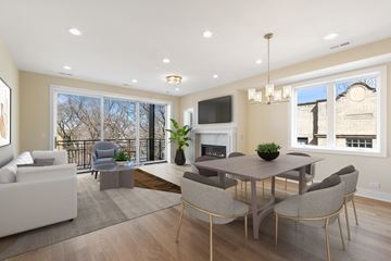 Chicago apartment for rent - A modern living room with a fireplace and a dining table set up.