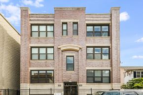 Chicago apartment for rent - A red brick building with a black gate in front.