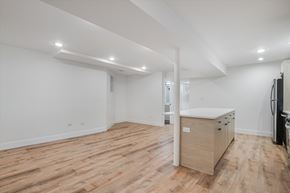 Chicago apartment for rent - A spacious room with wooden flooring and white walls.
