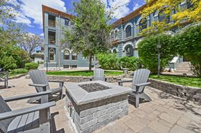 Denver apartment for rent - a patio with a fire pit and chairs in front of a building