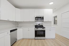 Evanston apartment for rent - A modern kitchen with white cabinets and stainless steel appliances.