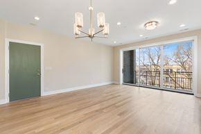 Chicago apartment for rent - a living room with a large window and a green door