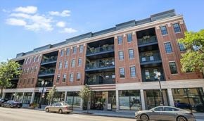 Chicago apartment for rent - A red brick building with balconies on the second floor.