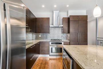 Chicago apartment for rent - A modern kitchen with a stainless steel refrigerator and wooden countertops.