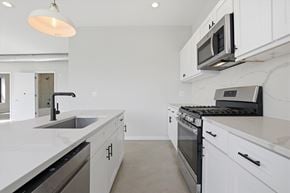 Chicago apartment for rent - A modern kitchen with white cabinets and stainless steel appliances.