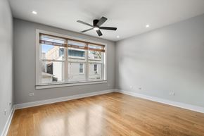 Chicago apartment for rent - A room with a ceiling fan and a window overlooking a building.