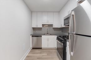 Chicago apartment for rent - a kitchen with white cabinets and stainless steel appliances