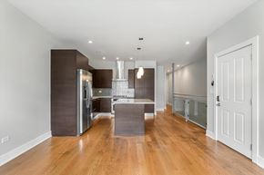 Chicago apartment for rent - A modern kitchen with wooden floors and a large island.