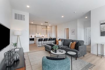 Chicago apartment for rent - A modern living room with a grey couch and a black coffee table.