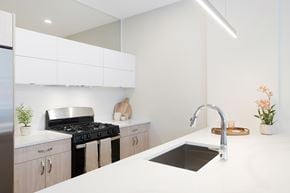 Chicago apartment for rent - A modern kitchen with a white countertop and a black stove.