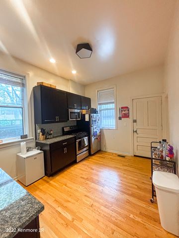Chicago apartment for rent - A kitchen with wooden floors and a black fridge.