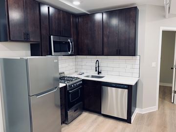 Chicago apartment for rent - A kitchen with dark wood cabinets and stainless steel appliances.
