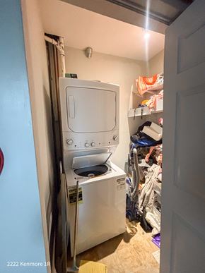 Chicago apartment for rent - A small white dishwasher is in a narrow space between a wall and a clothes dryer.