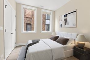 Chicago apartment for rent - A bedroom with a large bed and a painting on the wall.