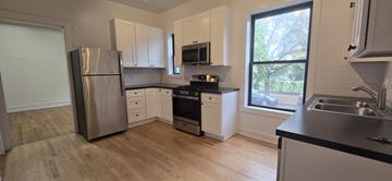Chicago apartment for rent - A kitchen with a stainless steel refrigerator and a window.
