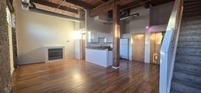 Chicago apartment for rent - A large open room with a fireplace and wooden floors.