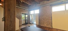 Chicago apartment for rent - A room with a wooden floor and a brick wall.