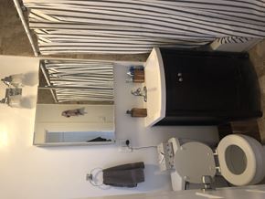 Chicago apartment for rent - A bathroom with a toilet, sink, and mirror.