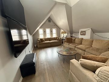 Chicago apartment for rent - A living room with a large couch and a television.