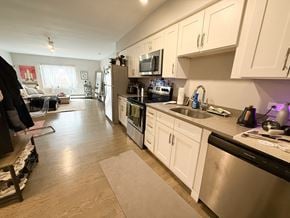 Chicago apartment for rent - A kitchen with white cabinets and a black dishwasher.