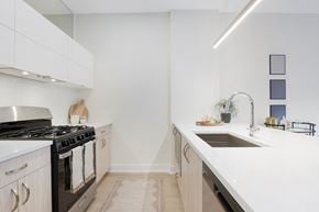 Chicago apartment for rent - A modern kitchen with a black stove and white cabinets.