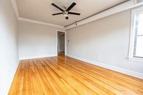 Chicago apartment for rent - A room with a ceiling fan and wooden flooring.