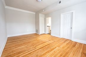 Chicago apartment for rent - A room with wooden floors and white walls.
