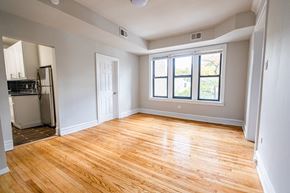 Chicago apartment for rent - A room with wooden flooring and a window with a view of trees.