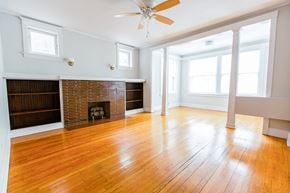 Chicago apartment for rent - an empty living room with wood floors and a brick fireplace