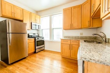 Chicago apartment for rent - a kitchen with wooden cabinets and stainless steel appliances