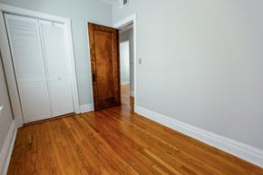 Chicago apartment for rent - a bedroom with wood flooring and a door to a closet