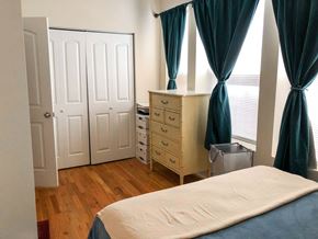 Chicago apartment for rent - A bedroom with a bed, dresser, and wardrobe.