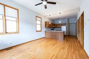 Chicago apartment for rent - A room with wooden floors and a ceiling fan.