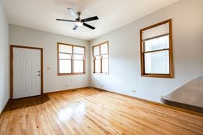 Chicago apartment for rent - A room with a ceiling fan and three windows.