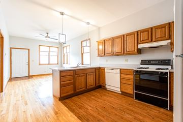 Chicago apartment for rent - A kitchen with wooden cabinets and a white dishwasher.