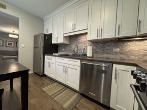 Chicago apartment for rent - A kitchen with white cabinets and a stainless steel dishwasher.