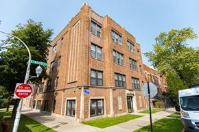 Chicago apartment for rent - A red brick building with a blue sign on the bottom right.
