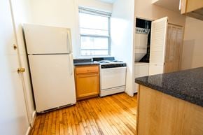 Chicago apartment for rent - A kitchen with a white fridge and wooden floors.